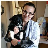 Dr. Amanda Espinosa, DVM, holding a puppy, showcasing her compassionate care and dedication to veterinary medicine.